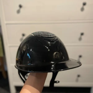 OneK Avance Glossy Swarovski-hjälm – svart - ⭐️ OneK Avance Glossy Swarovski-hjälm – svart, skal 2 Sparsamt använd, köpt okt -24 för 5599 kr. Slutade ridning och därför hann den inte användas så mycket. Alla stenar sitter, inga repor. Originalpåse & kartong. ⚠️ Linern ingår ej kan köpas till för 60kr i strl L 57-58. Säljes för 3700kr