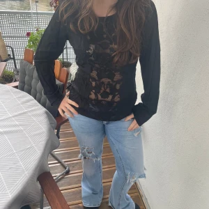 Svart långärmad blus med spetsdetaljer - Säljer en svart långärmad blus med transparenta spetsdetaljer framtill. Blusen har rund hals och är perfekt för dig som gillar att sticka ut med snygga detaljer. 💓💞