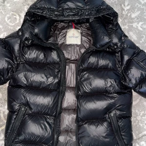 Svart Moncler Maya - Säljer en svart Moncler Maya. Använd men fortfarande i jättebra skick. Inga skador eller liknande bara en liten tråd e sliten på den tecknade bilden. Pris kan diskuteras vill bara sälja den