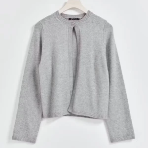 Grå kofta från Gina Tricot - En stilren grå kofta från Gina Tricot med rund halsringning och ribbade kanter. Koftan har en enkel knapp upptill och är långärmad. Perfekt att slänga över en t-shirt eller linne för en chill look. Mjuk och skön.  Köpte för 359 kr säljer för 250kr❤️