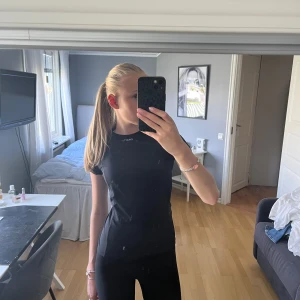 Svart träningst-shirt från Craft - PRISK KAN DISKUTERAS. Sportig svart t-shirt från Craft med rund hals och korta ärmar. Materialet är lätt och ventilerande polyester, perfekt för träning. Slimmad passform som sitter snyggt mot kroppen. Diskret Craft-logga framtill vid halsen. 