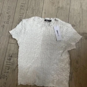 Vit blus  - Säljer en vit T-shirt blus. T-shirten har korta ärmar och en bekväm passform. 