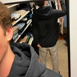 J.Lindeberg hoodie - Säljer en stilren svart hoodie från J.Lindeberg. Tröjan har en stor logga på ryggen och en klassisk huva. Perfekt för en avslappnad look.
