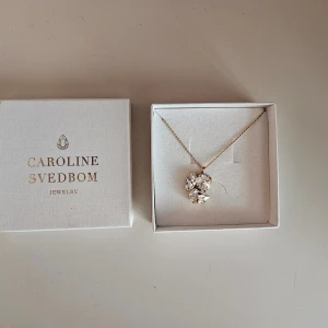 Caroline Svedbom Jolie Necklace Gold Crystal - Caroline Svedbom Jolie Necklace Gold Crystal i perfekt skick. Ursprungspris 995 kr. Finns inte kvar i sortimentet.   Storlek: 20×20 mm  Plätering: 18K Guld
