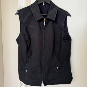 Svart väst med dragkedja - Stilren svart väst i mycket bra skick. Perfekt över en hoodie eller en t-shirt 