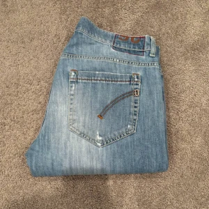 Dondup ljusblå jeans med slitningar model George  - Säljer ett par riktigt snygga Dondup jeans modell George! Jeansen är ljusblåa med snygga slitningar på. Det är bara att höra av sig vid minsta lilla fundering!😁