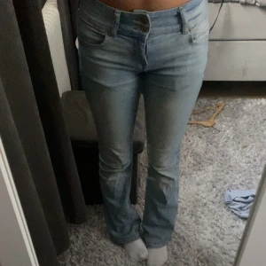 Bootcut jeans i ljusblå denim från Bershka - Snygga ljusblå bootcut jeans från Bershka i storlek 36. Jeansen har låg midja, klassisk femficksdesign och stängs med dubbla knappar. Tillverkade i stretchig denim för en bekväm passform och en trendig look. Mer bilder kan fixas❤️