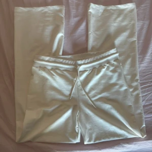 Vita mjukisbyxor från 157, storlek L - Säljer ett par vita mjukisbyxor från 157 i storlek L. Byxorna har resår i midjan med snörning och raka ben. Tillverkade i mjukt bomullsmaterial som är skönt mot huden. Perfekta för chill dagar eller när du vill vara bekväm.