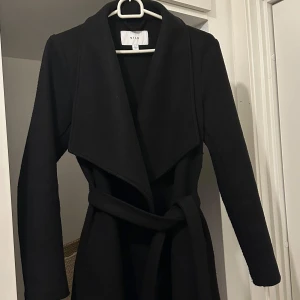 Svart kort kappa - Svart kappa från Vila i storlek 34. Lite nopprig men det kan enkelt fixas med noppermaskin. Fortfarande i bra skick.