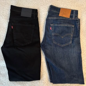 Levi's 502 blå & svarta jeans - Två par Levi's 502 jeans, ett par i klassisk blå denim och ett par i helsvart. Jeansen är knappt använda och är i mycket bra skick. 500 kr var per jeans