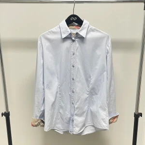 Burberry Skjorta - Vit Burberry skjorta med ikoniska mönstret i ärmar och krage. Fint skick.