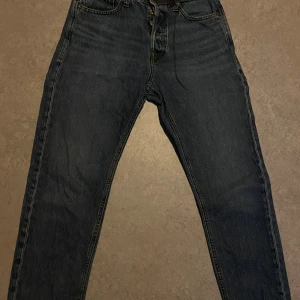 Jack & Jones Relaxed Chris jeans blå - Mörkblå jeans från Jack & Jones, modell Relaxed Chris. Klassisk femficksdesign med raka ben och avslappnad passform. Jeansen är tillverkade i bomull och har snygga kontrastsömmar. Perfekta för dig som gillar en chill och tidlös look.