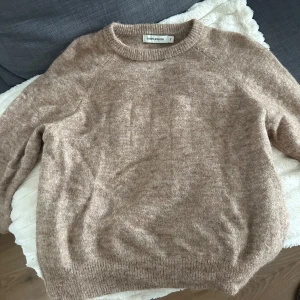 Beige stickad tröja från Carin Wester - Mysig beige stickad tröja från Carin Wester i storlek S. Tröjan har rund halsringning, långa ärmar och en lite fluffig känsla. Perfekt för lager-på-lager och chill dagar. Passar dig som gillar en enkel och stilren look.