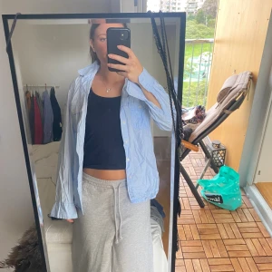 Blåvit randig skjorta från L.O.G.G. - Säljer en fitted blåvit randig skjorta från L.O.G.G. by H&M i bomull. Skjortan har klassisk krage, knappar framtill, två bröstfickor och ett broderat märke på ena ärmen. Perfekt för en chill och stilren look.