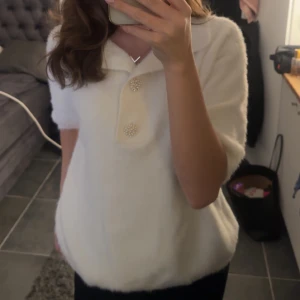 Vit fluffig tröja med pärlknappar - Supermjuk och fluffig vit stickad tröja med kortare ärmar och snygga pärlknappar framtill. Passar dig som gillar en stilren men ändå söt look. Köptes här på Plick, har endast använts en gång av mig och den är i jättebra skick, stl S💞