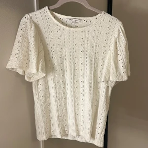 Vit spetsblus från ONLY - Superfin vit blus från ONLY med broderade detaljer och hålmönster. Blusen har korta, lite puffiga ärmar och rund halsringning. Knappt använd💞