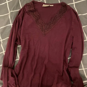 Vinröd långärmad topp med spets - Vinröd långärmad topp från Gina Tricot med snygg v-ringning och spetsdetaljer runt halsen. Mjuk och skön i bomullsmaterial, perfekt för hösten💕 Finns hundar här hemma men tvättas såklart innan jag skickar! (Pris kan diskuteras) nästan aldrig använd💗