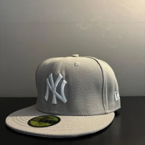 Grå New Era Yankees keps 59FIFTY - Snygg grå New Era 59FIFTY keps med klassisk New York Yankees-logga i vitt framtill. Perfekt för att ljusa upp den mörka hösten/vintern 🥶.  Har du frågor eller prisförslag? Kontakta mig gärna! Storlek: 7-1/8 (56,8cm) sick: 9/10