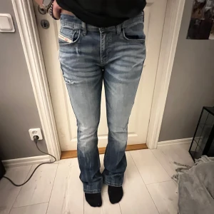 Lågmidjade Diesel Jeans - Säljer ett par blå bootcut jeans från Diesel med snygga slitningar, i storlek 16y men i referens passar de storlek 38/40🌟Pris kan diskuteras!! 