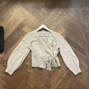 Beige knytkofta/omlottkofta Other stories - Säljer min beigea omlottkofta ifrån & Other stories. Kofta är använd några gånger men den är i jättefint skick! Stl: S. Om nån vill ha fler bilder så hör av er!❤️