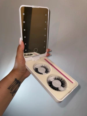 Fransbox med 2 par fransar och lim - Fransson med inbyggd spegel och lampor, går på cellbatterier och funkar felfritt, helt ny. 2 par fransar, medföljer lim i form av svart eyeliner. Fransarna kan användas upp till 60 gånger per frans. Förstör inte formen vid kontakt av vatten.