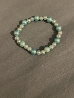 Armband  - Ett blått havsfärgat plast pärlarmband 