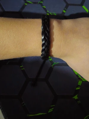 Flätat svart armband i skinnimitation - Säljer ett stilrent svart armband med flätad design och justerbar knytning. Armbandet är gjort i skinnimitation och passar perfekt för dig som vill ha en enkel men snygg accessoar till vardagslooken. Jag har bara använt de typ två gånger så i princip nytt, bara stått på hyllan 