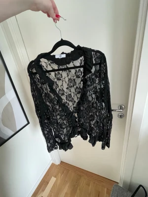 Spets kofta/blus med knytning  - En svart kofta/blus med knytning framtill, flera flera år tillbaka från H&M om jag inte minns helt fel. Storlek L