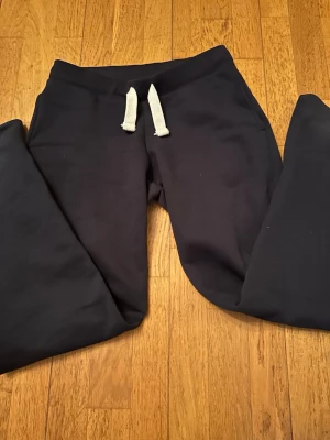 Svarta mjukisbyxor från Gina Tricot - Använts typ 2-3 gånger så de är helt nya. Trendiga och bekväma mjukisbyxor från Gina Tricot i mörkblå färg. Mjukt och skönt material med elastisk midja och dragsko för perfekt passform. Modellen har fickor baktill och en stilren look som funkar lika bra hemma som till vardags med en hoodie eller sweatshirt. 