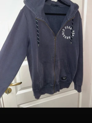 Marinblå PeakPerformance kofta  - Marinblå PeakPerformance kofta med dragkedja, tryck och luva. 