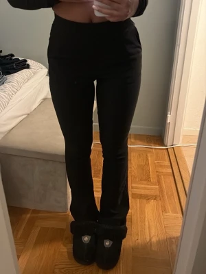 Svarta bootcut byxor från Vero Moda - Säljer ett par svarta bootcut byxor från Vero Moda. De har hög midja och sitter tight upptill med utsvängda ben. Materialet är mjukt och stretchigt. 