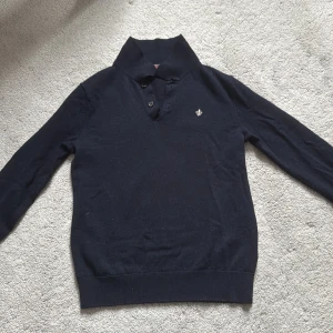 Mörkblå pikétröja i merinoull från Morris - Snygg mörkblå pikétröja från Morris i 100% merinoull. Klassisk krage, två knappar och diskret broderad logga på bröstet. Perfekt för dig som gillar stilrena och tidlösa plagg med en lyxig känsla.