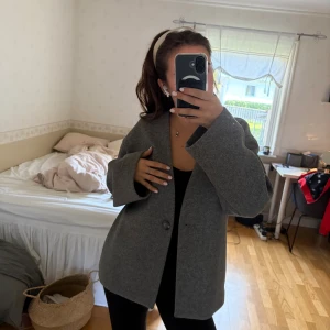 Grå kavajjacka från Bik Bok - Snygg grå kavajjacka från Bik Bok lite oversized modell med en knapp framtill. Jackan har lång ärm. I ny skick, finns fickor i sidan. Extra knapp finns. Inga noppror. Skriv för frågor eller prisförslag