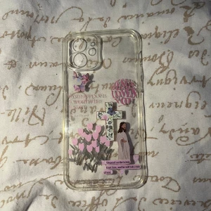 iPhone 11 Skal med kristna motiv - Transparent skal till iPhone 11 med kristna motiv, inklusive kors, Jesus och inspirerande texter. Skalet är i gott skick utan synliga repor eller sprickor. Perfekt för dig som vill skydda din mobil och samtidigt visa din tro.