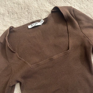 Brun topp från NA-KD🤎 - En brun ribbad croppad topp från NA-KD med fyrkantig halsringning och långa ärmar. Passar super bra till hösten🤍