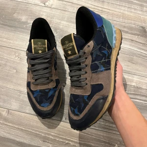 Valentino Garavani Rockrunner sneakers - Valentino rockrunners i strl 40. Skicket är bra, har en del tecken på användning, som man ser på bilden är det ett litet hål på insidan av skon, vilket knappt syns vid användning. Men annars riktigt snygga och fräscha. Skriv vid funderingar 