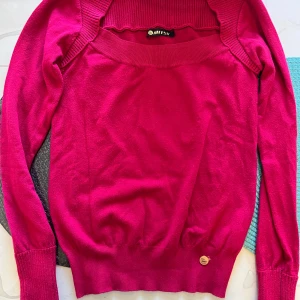 Mörkrosa stickad tröja från Mitsy - Snygg mörkrosa stickad tröja från Mitsy med bred ribbad kant vid hals och axlar. Tröjan har långärmad design och en liten metallbricka vid nederkanten. Perfekt för dig som gillar färg och vill ha en bekväm och stilren look. Snabb leverans 📦. Gärna kolla på mina andra plagg ( bästs priser vid köp med bundle)