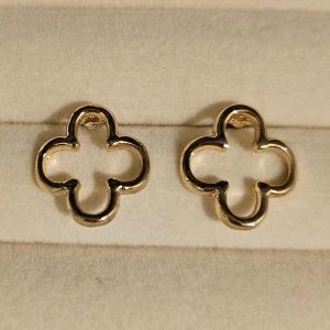 Guldiga fyrklöver örhängen - Snygga örhängen i form av öppna fyrklöver, tillverkade i guldtonad metall. Den stilrena designen gör dem till ett statement piece som lyfter din look. Perfekt för dig som gillar unika och trendiga accessoarer.