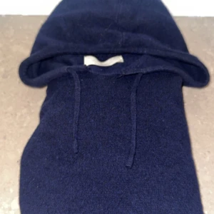 Mörkblå hoodie i kashmir  - Säljer en  mörkblå hoodie från Sayless i kashmir. Tröjan har huva med snörning och långa ärmar, perfekt för dig som vill ha en stilren och bekväm tröja. Enkel design utan tryck eller mönster, passar till allt. Bra kvalitet!