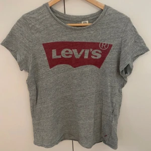 Levis T-shirt - Grå t-shirt från Levi's med klassisk röd logga framtill i strl M 🌸