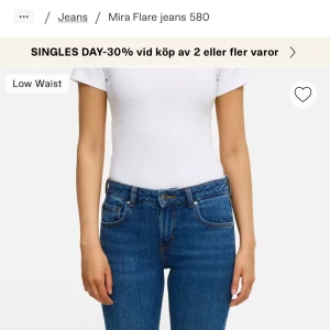 Blå Mira Flare jeans W26 L32 - Snygga blå Mira Flare jeans med låg midja och klassisk femficksdesign. Jeansen har en utsvängd bootcut-passform och är tillverkade i slitstarkt denimmaterial. Perfekta för dig som gillar retrovibbar och vill ha en cool siluett. Använda kanske två gånger