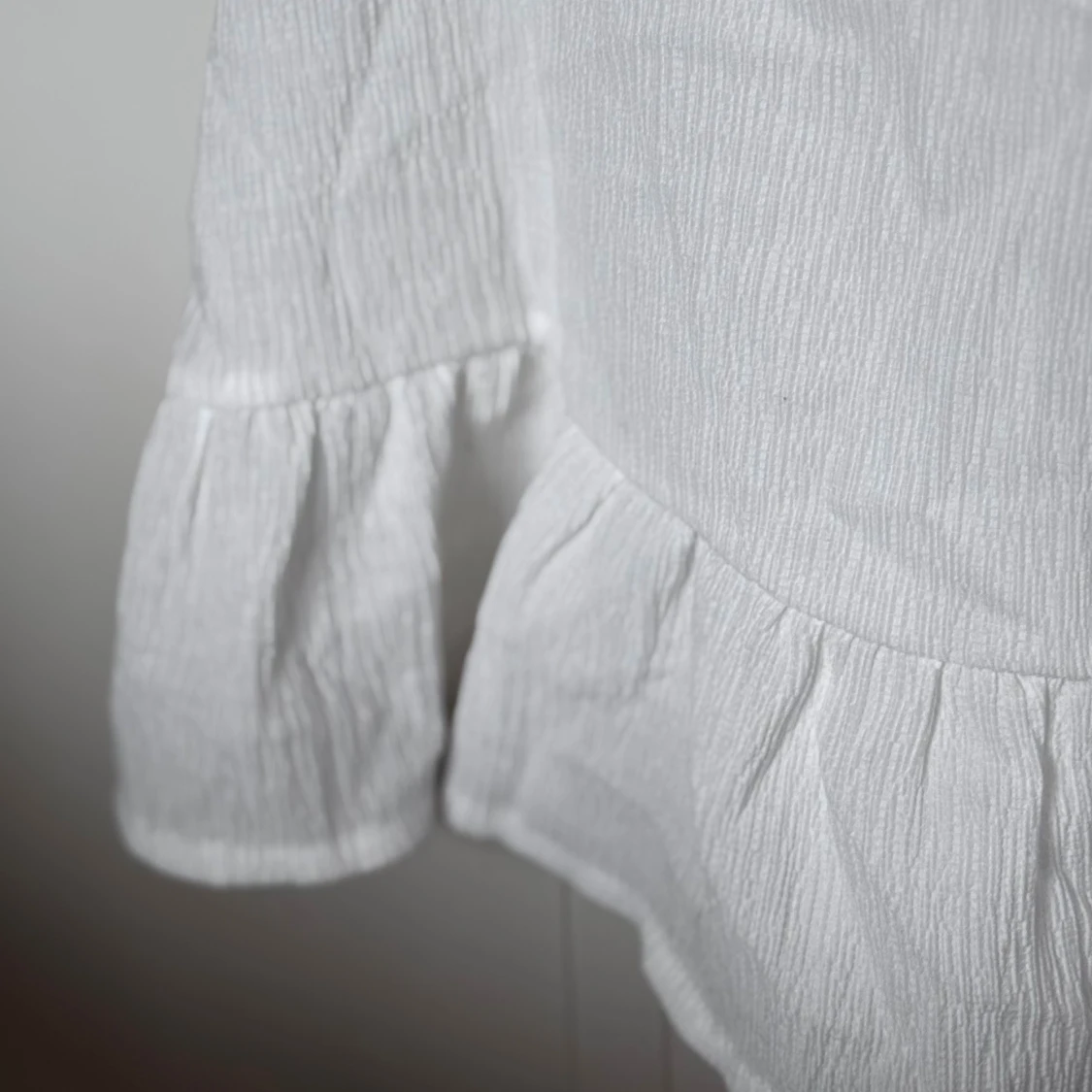 Vit linnetopp med volang