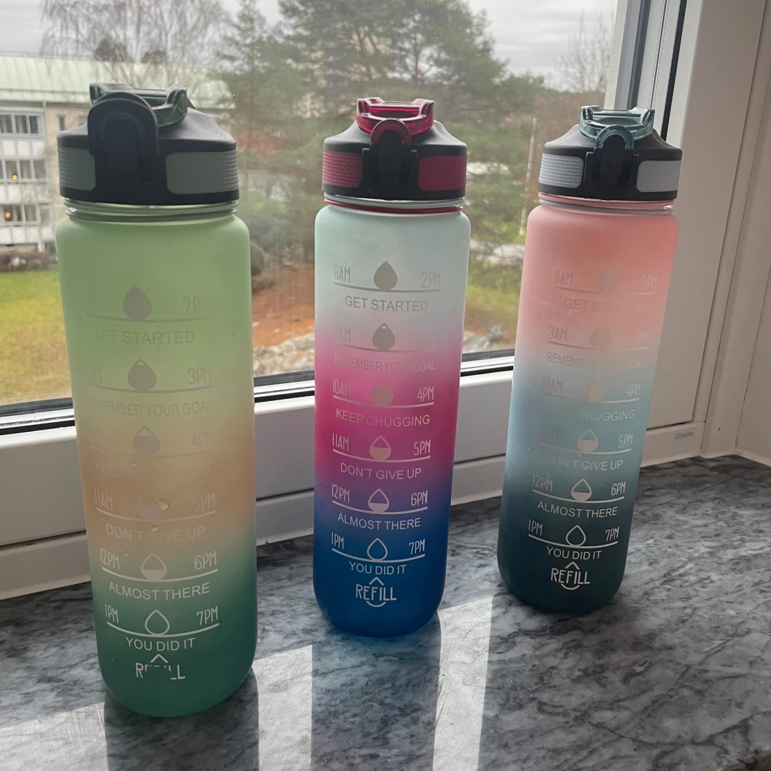 Flerfärgade vattenflaskor med tidsmarkeringar