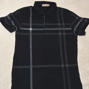 Burberry Piké  - Otroligt snygg Burberry piké som jag har köpt i Milano. Denna piken är väldigt svårt o få tag på då den säljs knappt längre. Den passar både dig med storlek M och L, jag har M och den passar mig perfekt. Säljer billigt då jag inte använder sånna här märken längre! Först till kvarn!!