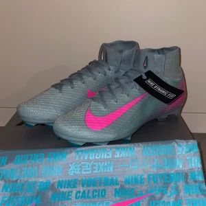 Nike Mercurial Superfly Elite - Nike Mercurial superfly elite fotbollsskor i grön med neonrosa swoosh och detaljer. Skorna har snörning, hög strumpkrage och Dynamic Fit-teknologi för extra stöd. Sulan är designad för grepp på planen och har rosa och turkosa inslag. Perfekt för dig som vill sticka ut på fotbollsplanen. Nypris cirka 3,3k Dom är endast använda 2 gånger, säljer då dom inte passar mig☺️