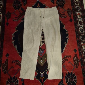 Beiga linnebyxor från Dressmann XL - Snygga beiga linnebyxor från Dressmann i storlek XL. Byxorna har dragsko i midjan, raka ben och två bakfickor med knapp. Perfekta för chill dagar när du vill ha en luftig och avslappnad stil.