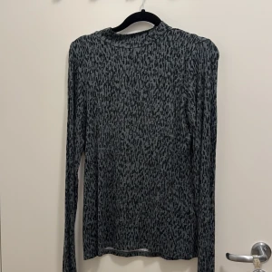 Grön leopardmönstrad långärmad tröja Lindex - Snygg långärmad tröja från Lindex i storlek S med grön leopardmönster. Tröjan har en rund hals och är tillverkad i mjukt, stretchigt material som sitter skönt mot kroppen. Perfekt för dig som gillar djurmönster och vill ha en cool look.