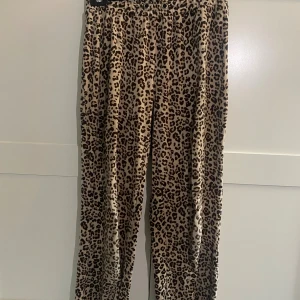 Leopardmönstrade byxor Gina Tricot - Snygga byxor från Gina Tricot i storlek XS med leopardmönster. Byxorna har rak passform och är i mjukt, stretchigt material. Perfekta för dig som vill sticka ut med ett djuriskt print och bekväm stil.