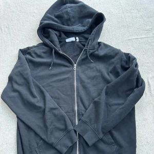 Svart zip hoodie från weekday - Svart zip hoodie med huva.