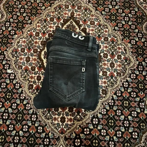 Svarta jeans från Dondup (George), stl 30 - Säljer ett par väldigt eftertraktade svarta jeans från dondup i storlek 30. Jeansen har klassisk femficksdesign, diskret D-detalj på bakfickan.De är stretchiga och sitter skönt hela vägen ner. Perfekta för dig som gillar en stilren modell. Hör av er vid frågor eller funderingar.                                                           Priset kan diskuteras!